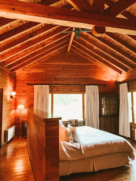 Dormitorio con cama matrimonial bajo el techo de madera