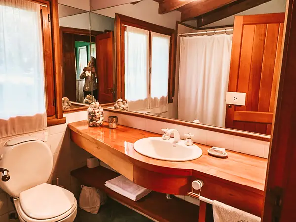 Baño con mesada de madera y ventana