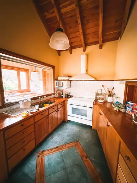 Cocina con muebles de madera y ventana