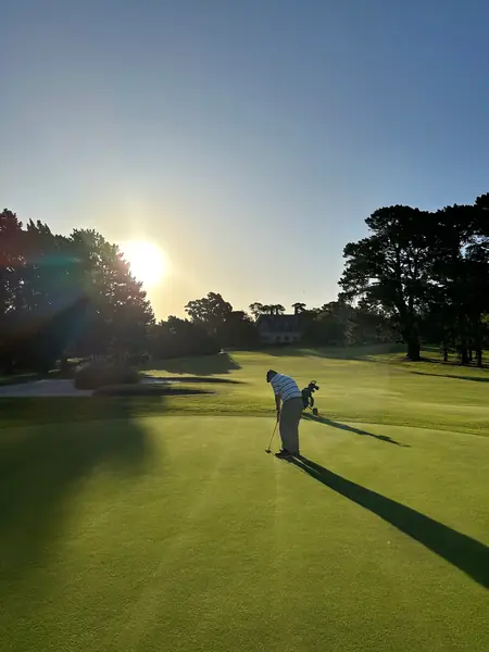 Golfista en el green al atardecer