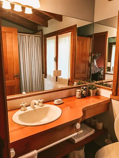 Baño con mesada de madera y espejo