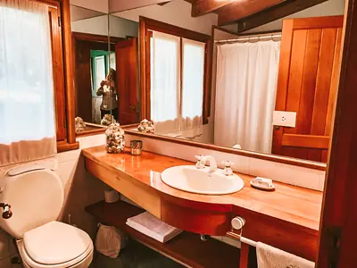 Baño con mesada de madera y ventana