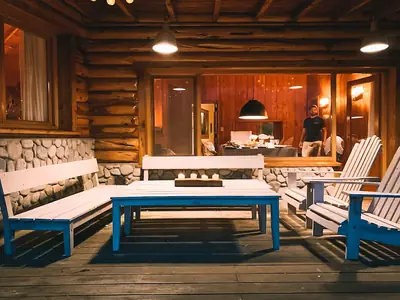 Galería cubierta con sillones y mesa de madera