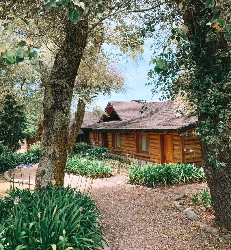 Sendero de entrada a la casa entre árboles y canteros